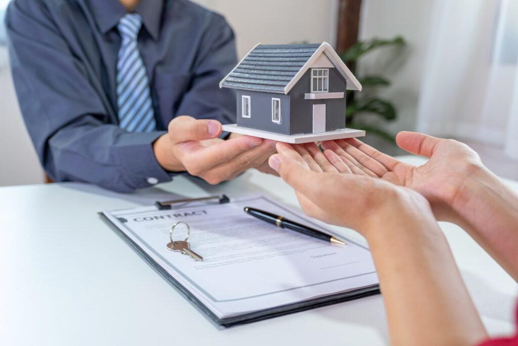 Real estate agents and buyers discuss signing a business contract, renting, buying or home insurance